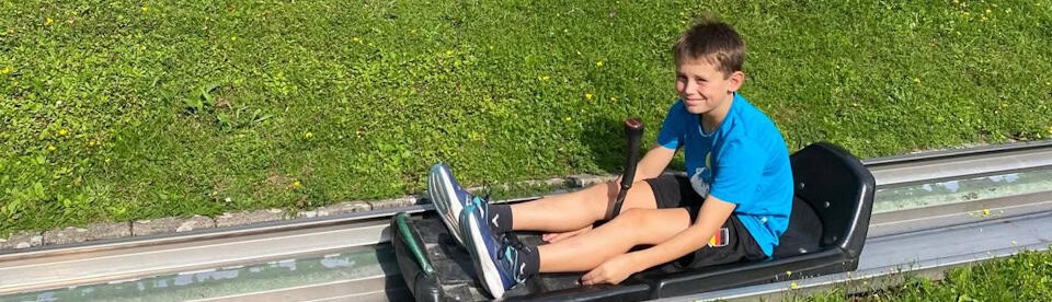 Junge auf der Sommerrodelbahn