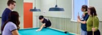 Jugendliche spielen zusammen Billard