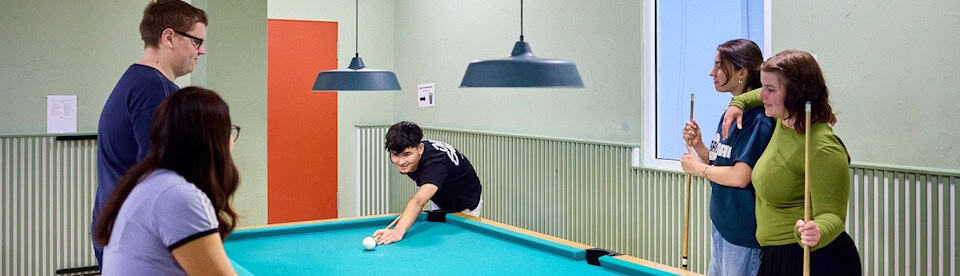 Jugendliche spielen zusammen Billard