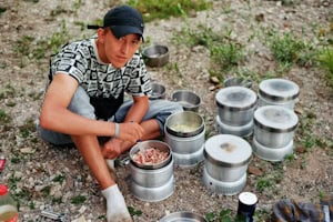 Eine Junge ist draußen am Essen kochen