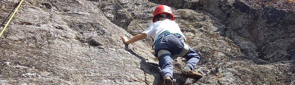 Ein Junge beim Klettern am Fels