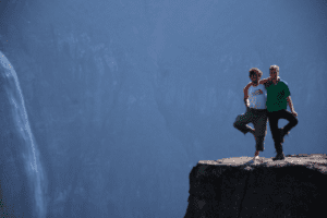 Zwei Männer im Yogabaum vor einem Wasserfall