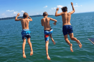 Drei Jungs springen in den Chiemsee