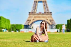 Mädchen sitzt vor dem Eifelturm in Frankreich