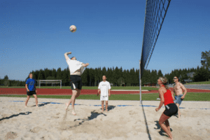 Campteilnehmer spielen Beachvolleyball