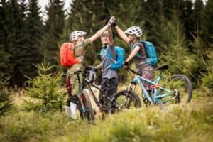 Drei Mountainbiker klatschen sich ab