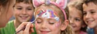 Kind beim Einhorn schminken