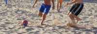 Jungen beim Fußballspielen am Strand