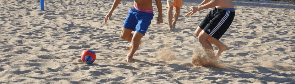 Jungen beim Fußballspielen am Strand