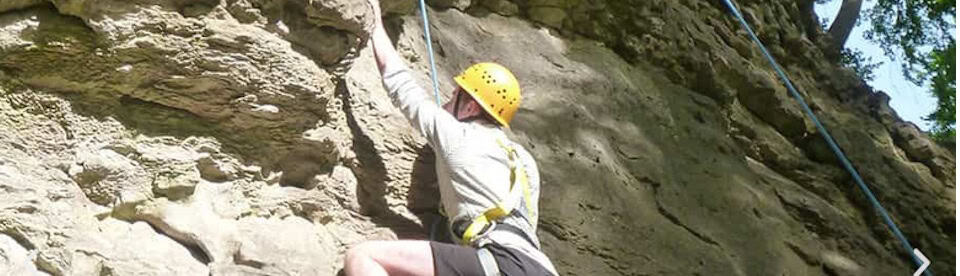 Teilnehmer am Klettern an einer Felswand