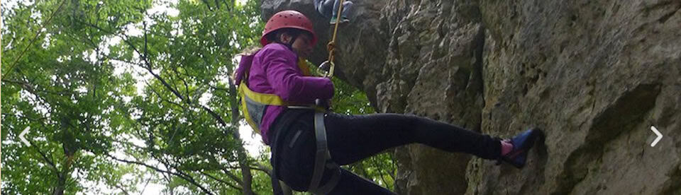 Ein Mädchen klettert am Felsen