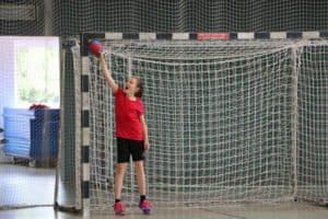 Mädchen steht in Handballtor