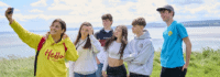 Sprachschüler stehen auf den Klippen vor dem Meer