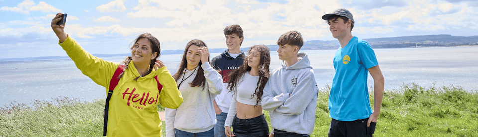 Sprachschüler stehen auf den Klippen vor dem Meer