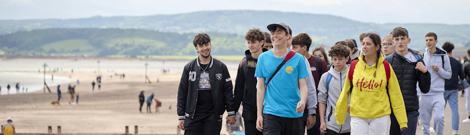 Jugendliche spazieren entlang der Promenade in Exmouth
