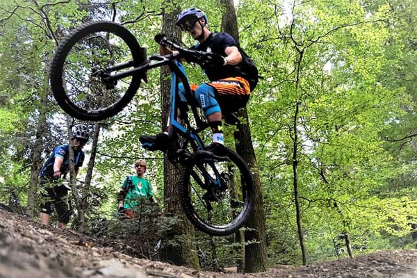 Mountainbiker jumpt durch Wald