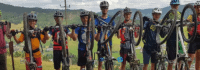 Mountainbiker Gruppe steht in einer Reihne und halten ihre Mountainbikes hoch