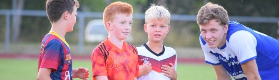 Kinder und Trainer auf dem Fußballplatz