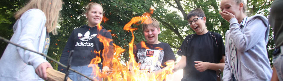 Kinder um ein Lagerfeuer herum