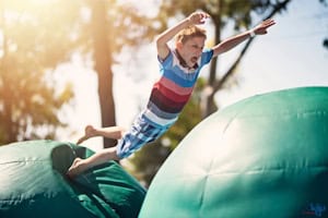 Junge hüpft auf einem Sprungkissen