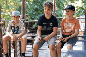 Drei Jungs sitzen auf Bank nebeneinander