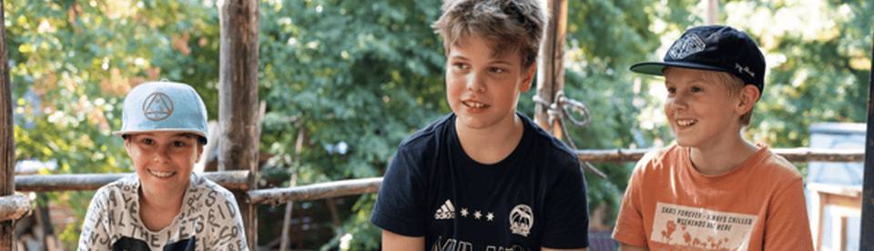 Drei Jungs sitzen nebeneinander