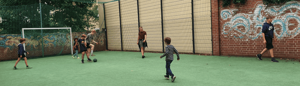 Kinder spielen Fußball auf dem Platz