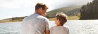 Vater und Sohn sitzen am See