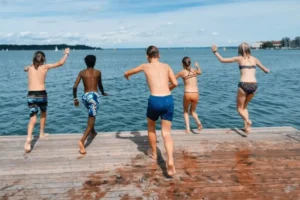 Kinder springen ins Wasser im Englisch Camp am Möhnesee