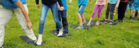 Kinder spielen auf Wiese Kooperationsspiel