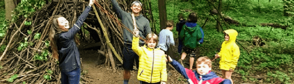 Kinder stehen vor Holzunterschlupf