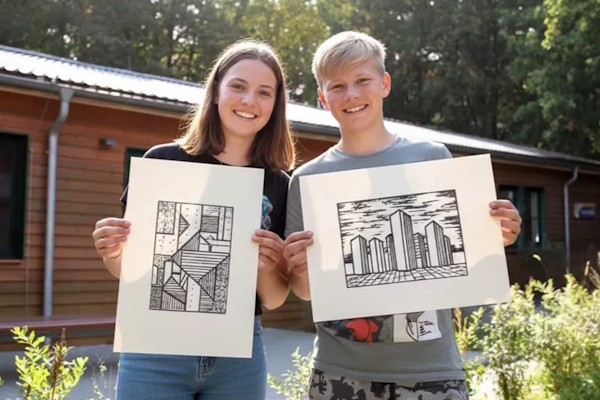 Zwei Teilnehmende präsentieren stolz ihre Zeichnungen im Kunst Daycamp