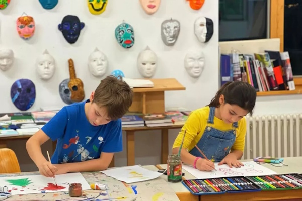 Zwei Kinder malen gemeinsam im Erlebnis Daycamp
