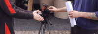 Eine Kamera steht zwischen zwei Menschen