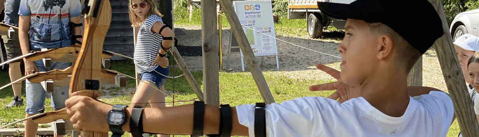 Junge ist konzentriert beim Bogenschießen