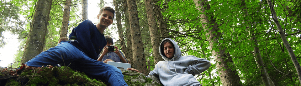 Drei Jungs spielen im Wald