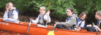 Eine Gruppe Kinder sitzt in einem Kanu