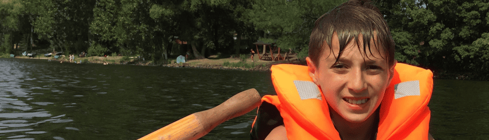 Junge sitzt auf Ruderboot