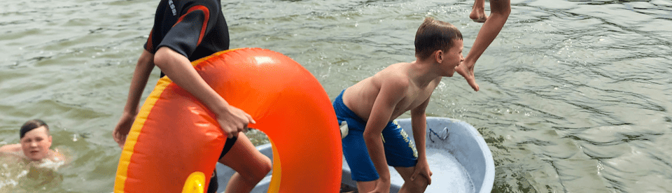 Kinder spielen im See