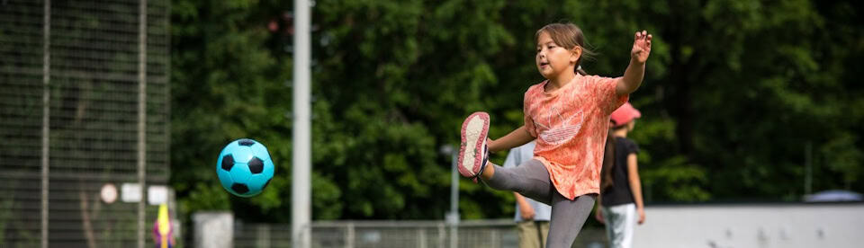 Mädchen schießt den Ball hoch