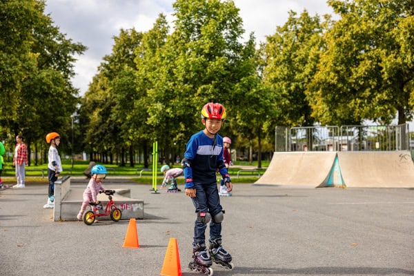 Junge fährt mit Inlinern durch einen Parcour