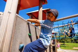 Ein Junge klettert im Parkour Tagescamp