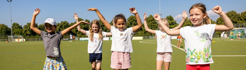 Fünf Mädchen machen zusammen Aufwärmübungen