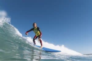 Junge surft auf einer Welle