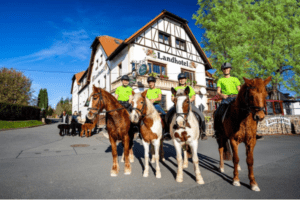 Kinder auf Pferden vorm Landhotel
