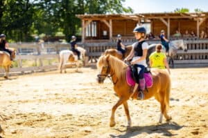 Mädchen reitet auf Pferd im Rundgang, Reiterferien in Thüringen