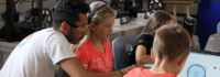 Betreuer und Kinder vorm Laptop