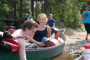 Jugendliche lachend im Kanu an Land