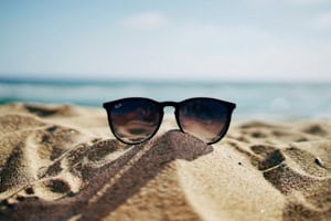 Sonnenbrille im Sand