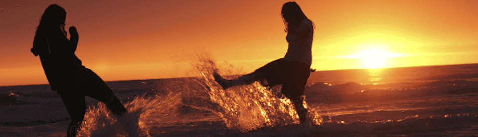 Zwei Teilnehmer spielen im Wasser beim Sonnenuntergang